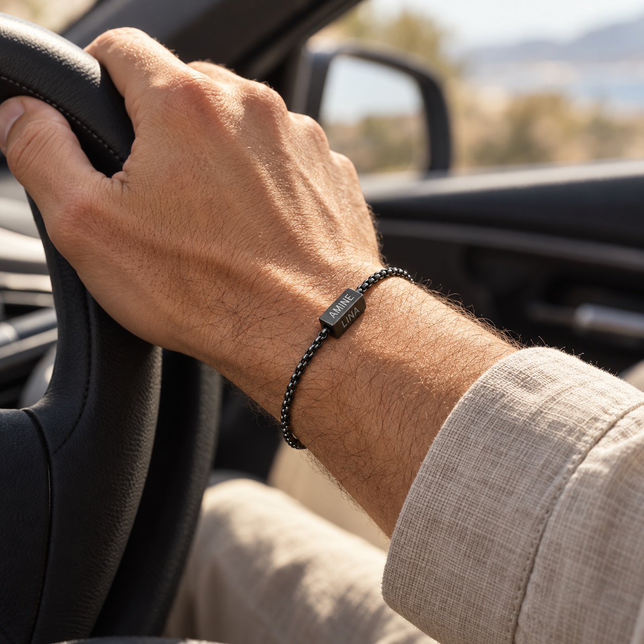 Bracelet noir gravé AMINE et LINA porté au volant